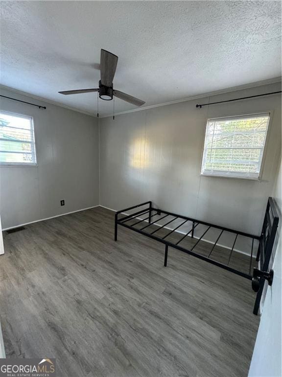 unfurnished room with ceiling fan, dark hardwood / wood-style flooring, and a healthy amount of sunlight