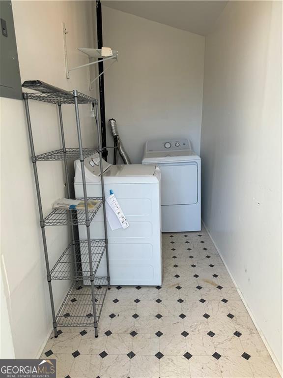 laundry area with washing machine and dryer and electric panel