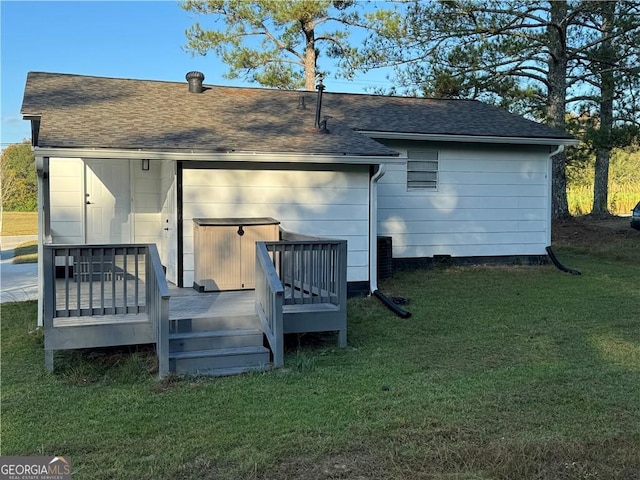 rear view of property featuring a lawn and a wooden deck