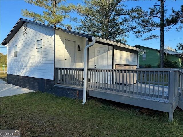 back of property featuring a lawn and a deck