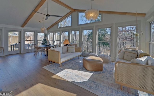 sunroom / solarium with vaulted ceiling with beams, ceiling fan with notable chandelier, and a wealth of natural light