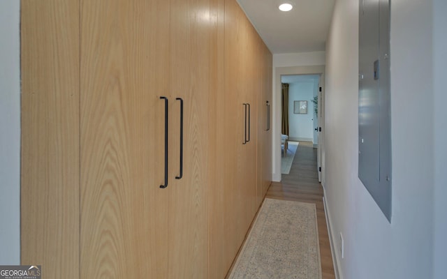 hall with light wood-type flooring, baseboards, and recessed lighting