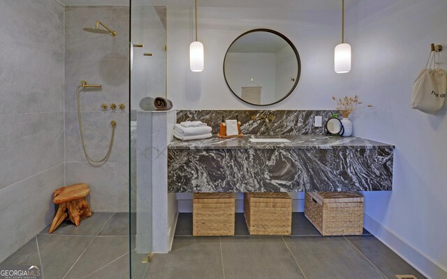 bathroom with tiled shower and sink