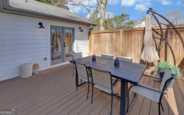 wooden deck with fence, outdoor dining area, and french doors