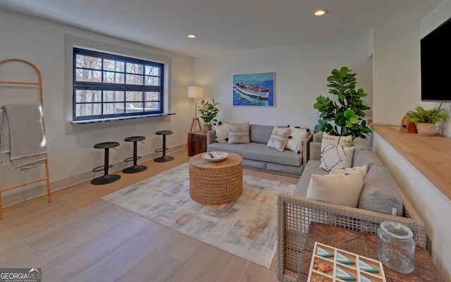 living area with baseboards, wood finished floors, and recessed lighting