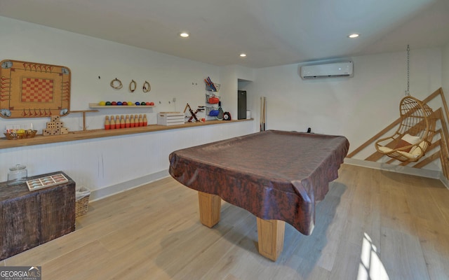 rec room featuring light wood-type flooring, an AC wall unit, and billiards