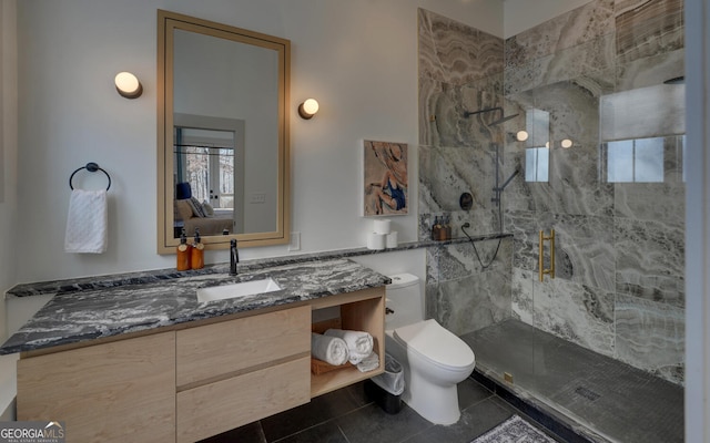 bathroom with tile patterned floors, toilet, vanity, and tiled shower