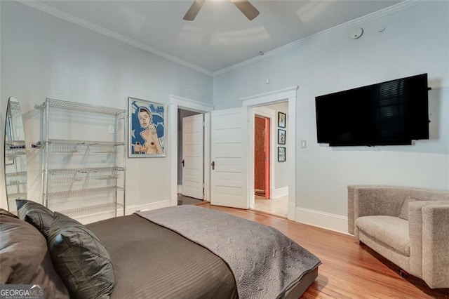 bedroom featuring hardwood / wood-style flooring, ceiling fan, and crown molding