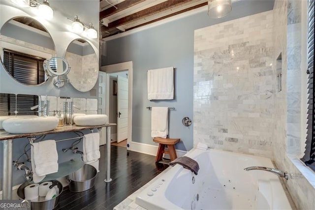 bathroom featuring wood-type flooring, sink, and tiled bath