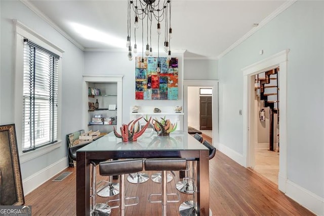 dining space featuring hardwood / wood-style flooring and crown molding