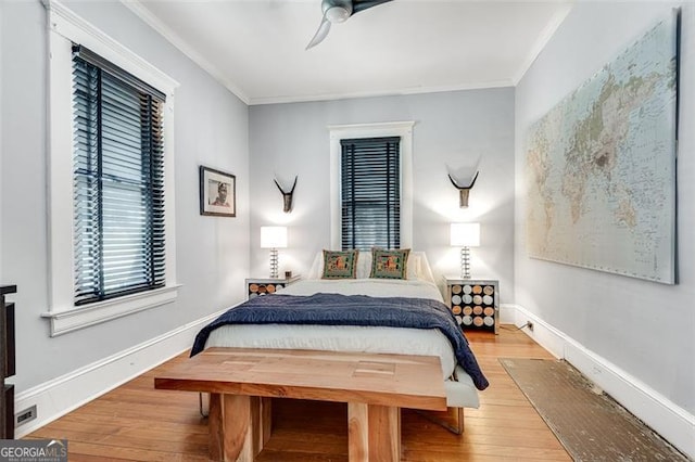 bedroom featuring light hardwood / wood-style floors, ceiling fan, and crown molding