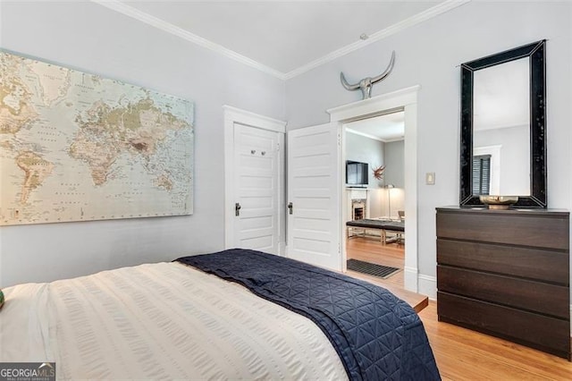 bedroom with light hardwood / wood-style floors and ornamental molding