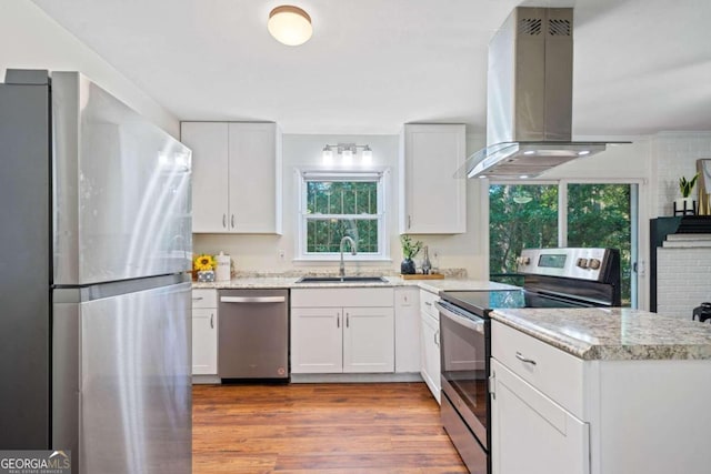 kitchen featuring white cabinetry, island range hood, sink, and appliances with stainless steel finishes