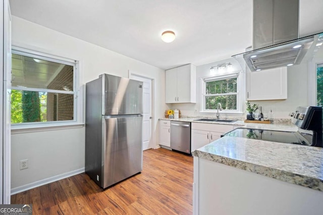 kitchen featuring white cabinetry, sink, wood-type flooring, and appliances with stainless steel finishes