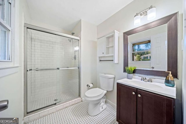 bathroom with tile patterned flooring, vanity, toilet, and an enclosed shower