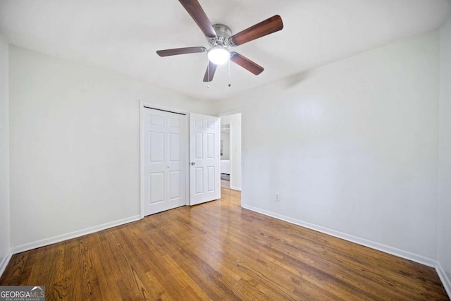 unfurnished bedroom with ceiling fan, a closet, and hardwood / wood-style flooring