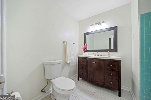 bathroom featuring tile patterned floors, vanity, and toilet