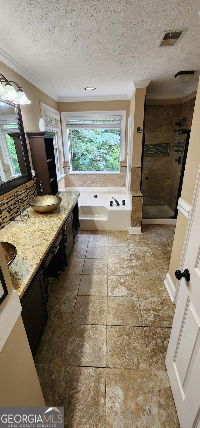 bathroom featuring crown molding, vanity, a textured ceiling, and shower with separate bathtub