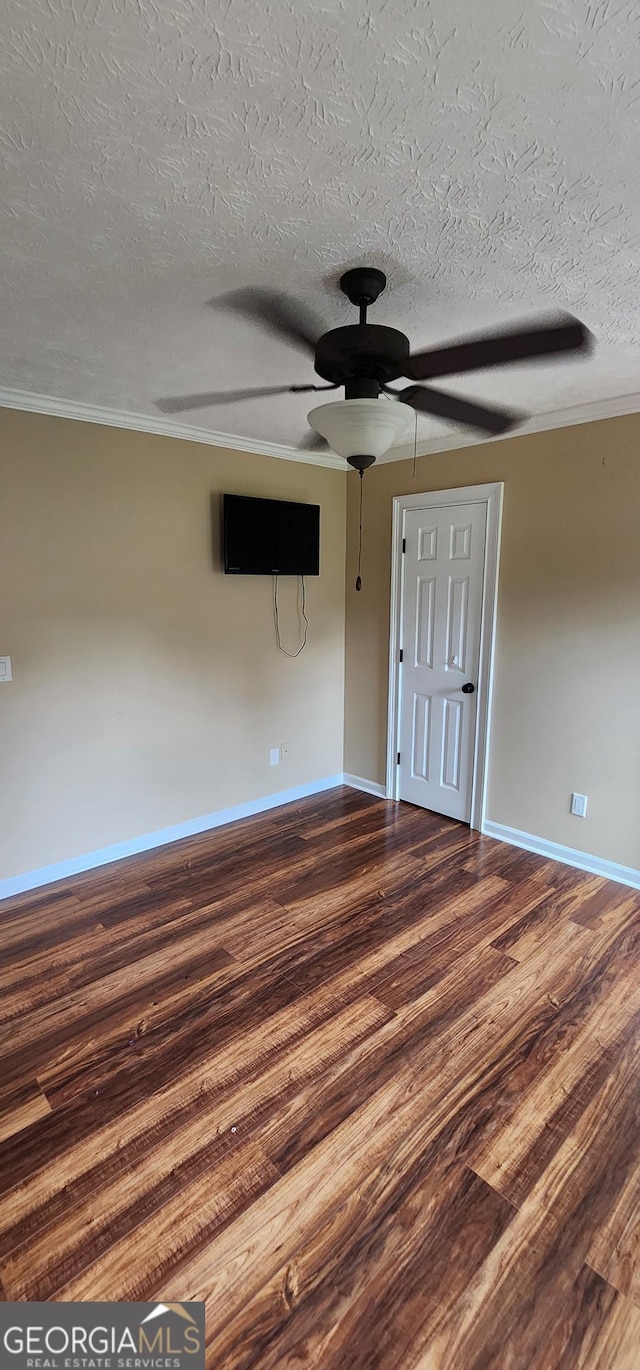 unfurnished room featuring a textured ceiling, crown molding, and dark hardwood / wood-style floors