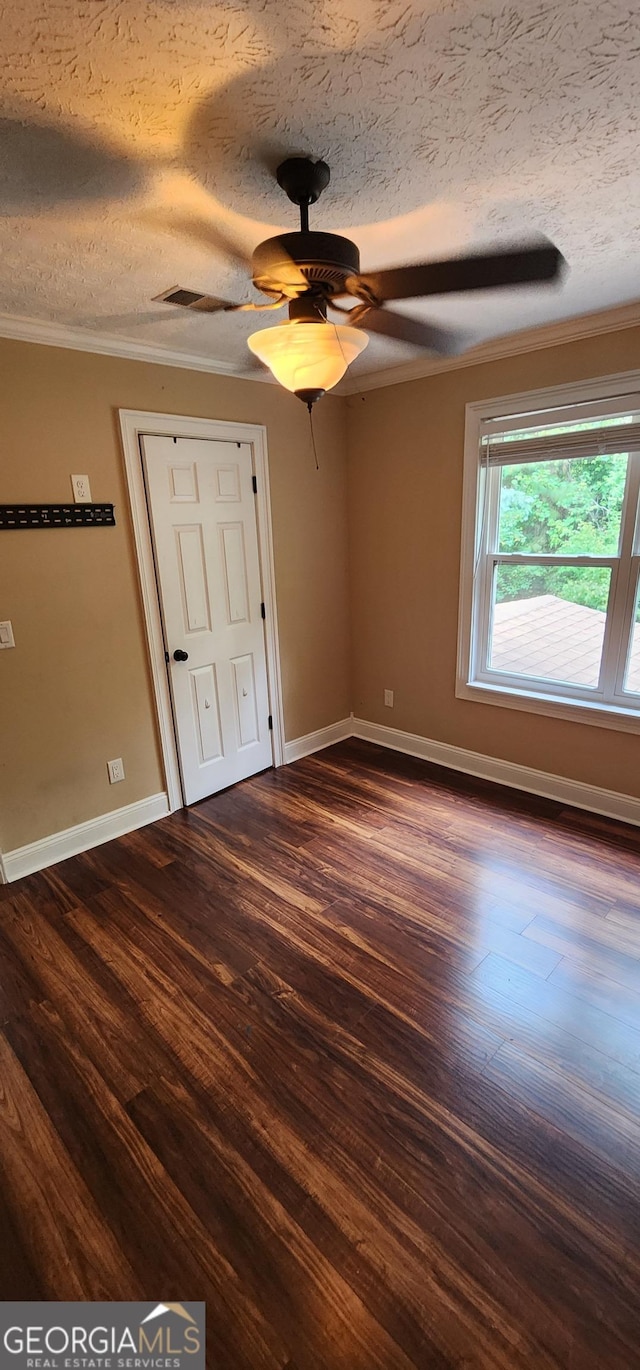 unfurnished bedroom featuring ceiling fan, dark hardwood / wood-style flooring, ornamental molding, and a textured ceiling