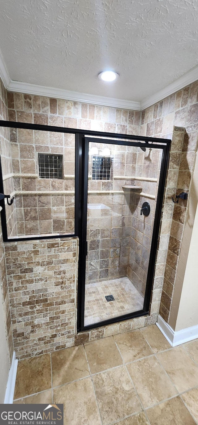 bathroom featuring an enclosed shower, ornamental molding, and a textured ceiling