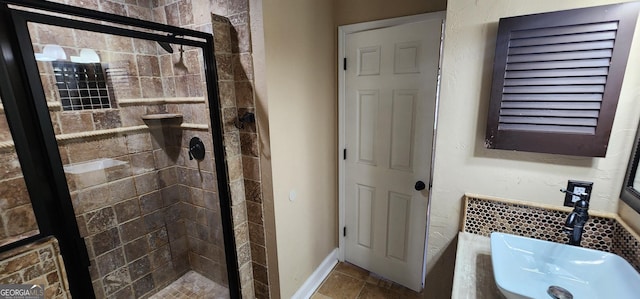 bathroom featuring tile patterned flooring, a shower with shower door, and sink