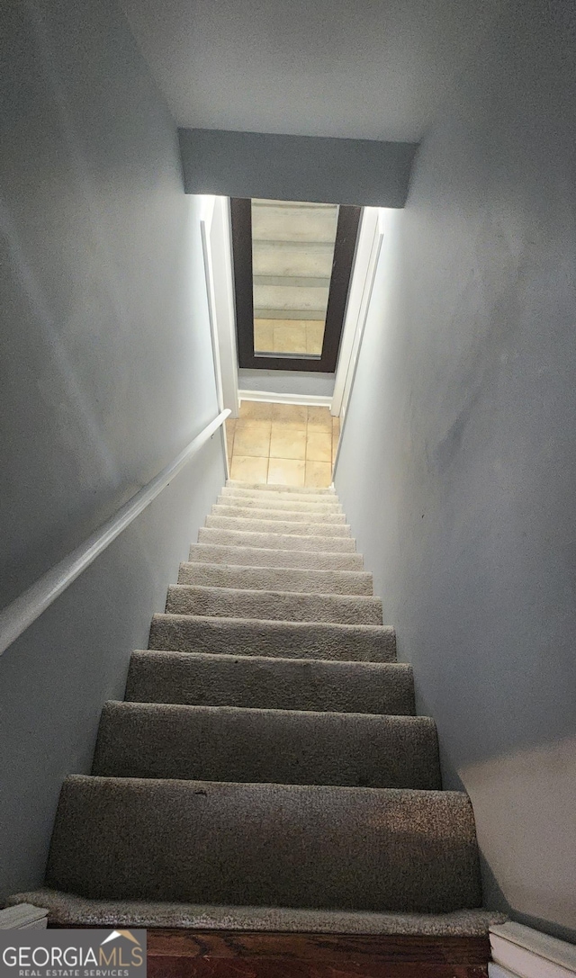 staircase featuring tile patterned flooring