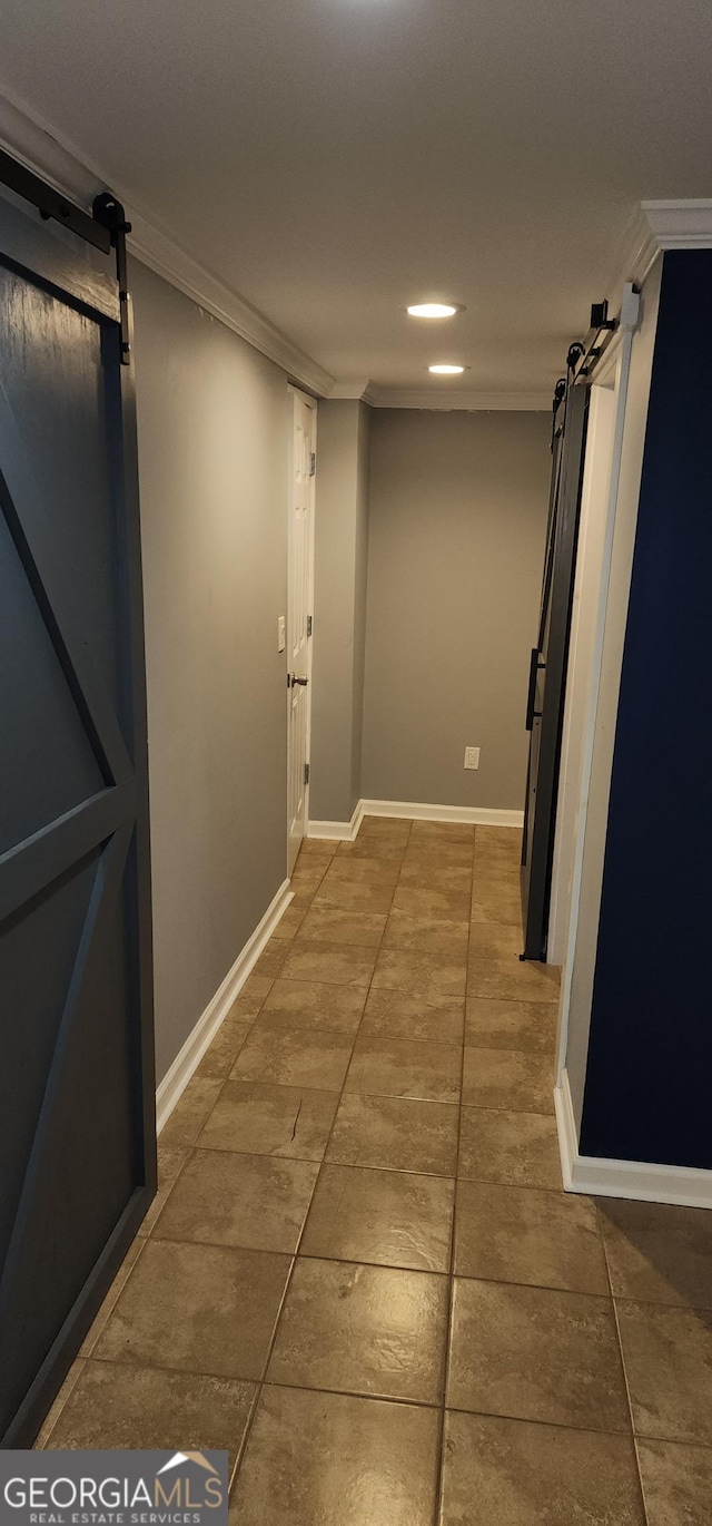 corridor with a barn door and crown molding