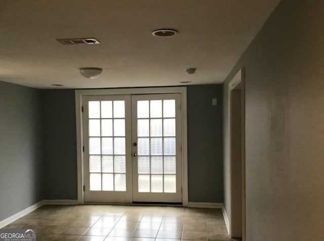 doorway to outside featuring french doors, light tile patterned floors, and a healthy amount of sunlight