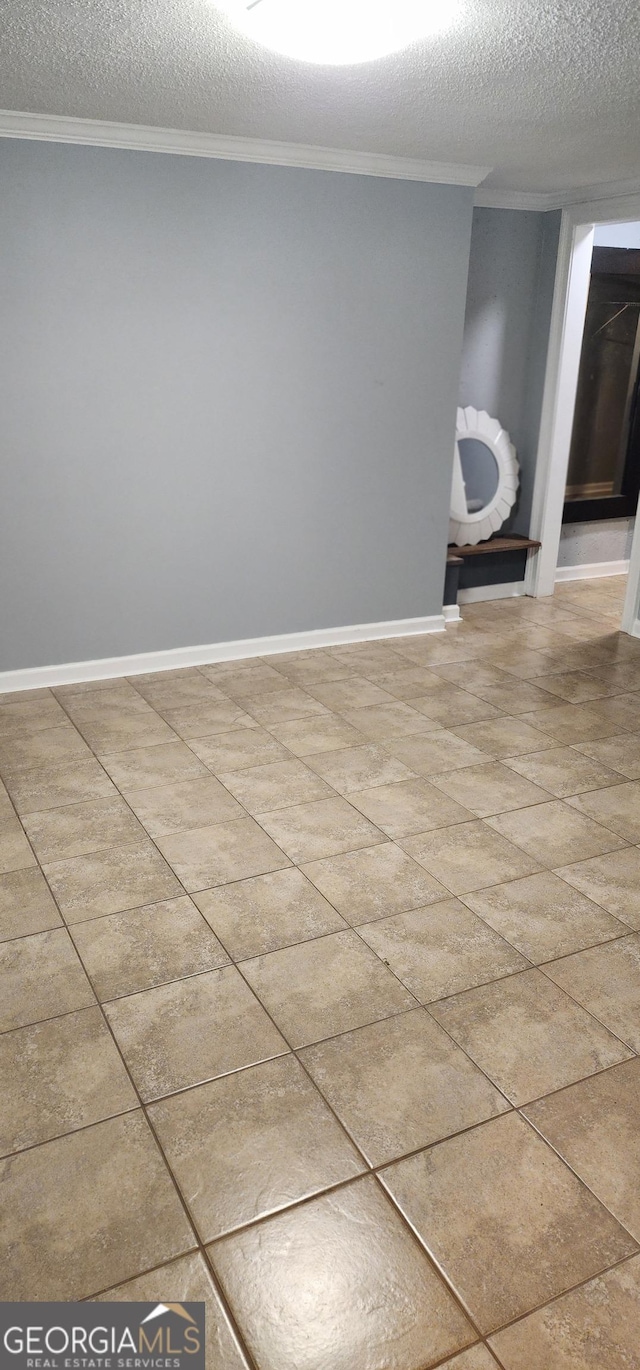 spare room with tile patterned flooring, a textured ceiling, and ornamental molding