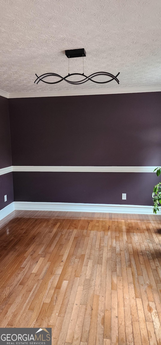 unfurnished room featuring hardwood / wood-style floors and a textured ceiling