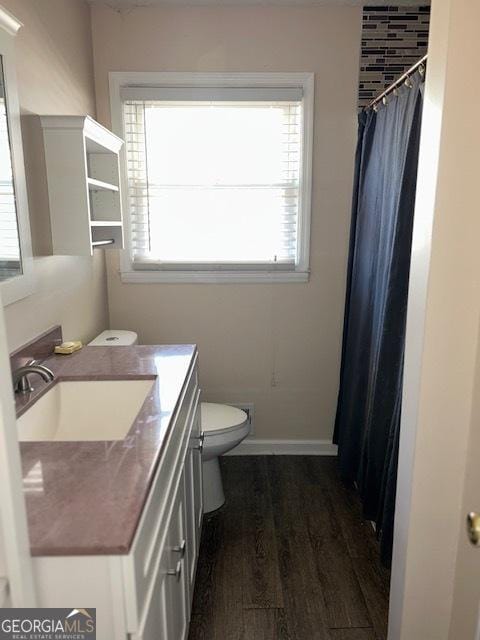 bathroom with hardwood / wood-style floors, vanity, and toilet