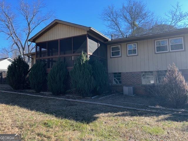 back of house featuring a sunroom and central AC unit