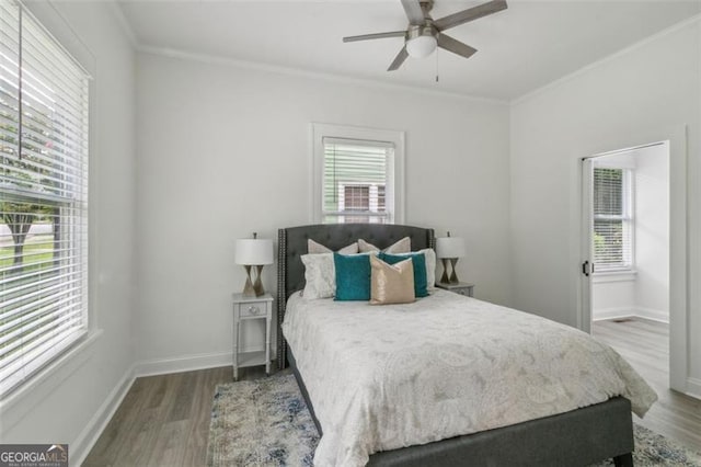 bedroom featuring hardwood / wood-style flooring, ceiling fan, and ornamental molding