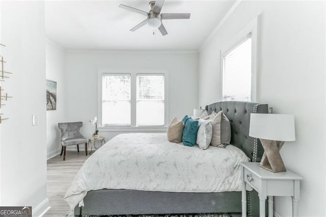 bedroom with multiple windows, light hardwood / wood-style floors, and ceiling fan