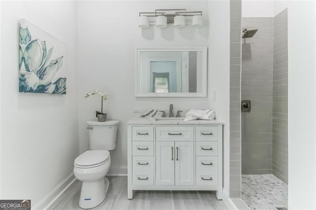 bathroom featuring vanity, toilet, and tiled shower