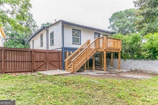 rear view of house with a deck and a yard