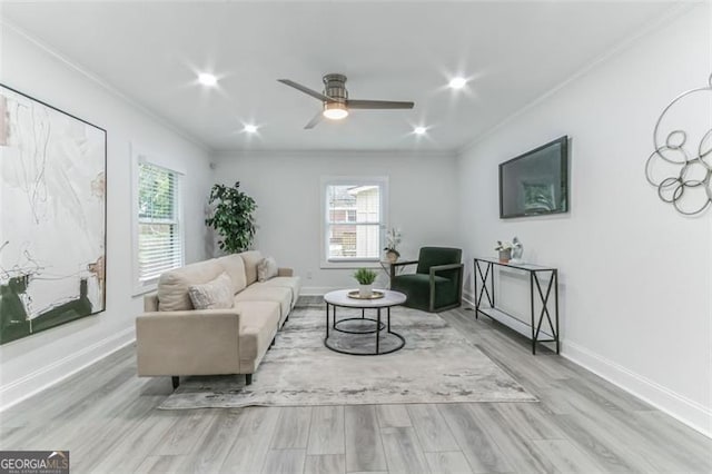 living room featuring ceiling fan, crown molding, a wealth of natural light, and light hardwood / wood-style flooring