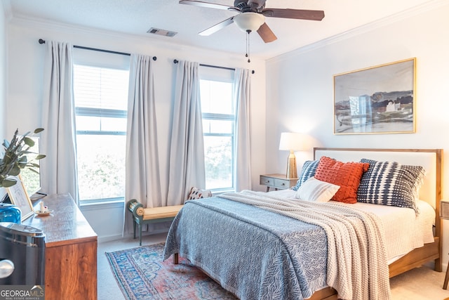 carpeted bedroom featuring ceiling fan and ornamental molding