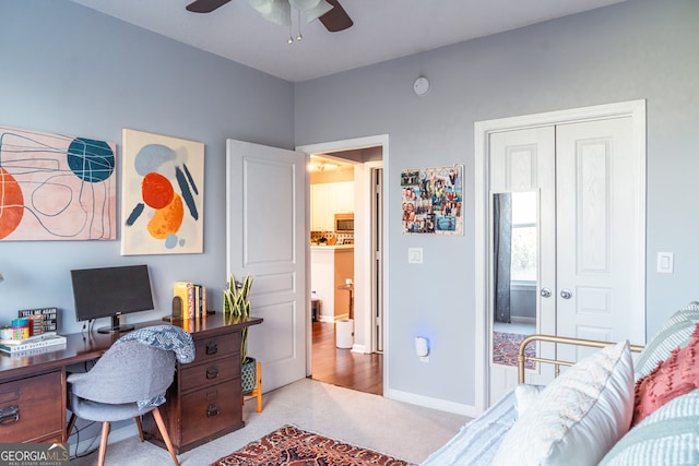 carpeted office space featuring ceiling fan