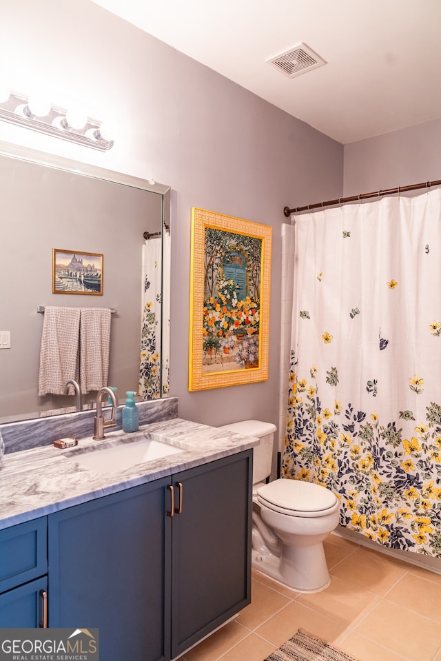 bathroom featuring tile patterned flooring, vanity, and toilet