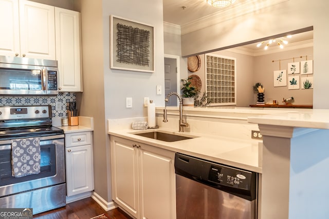 kitchen with white cabinets, sink, dark hardwood / wood-style floors, ornamental molding, and appliances with stainless steel finishes