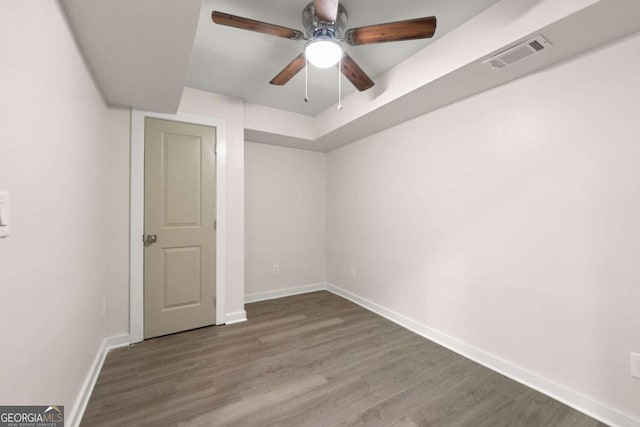 unfurnished room featuring ceiling fan and dark wood-type flooring