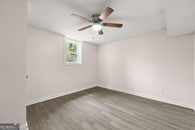 unfurnished room with ceiling fan and dark hardwood / wood-style flooring