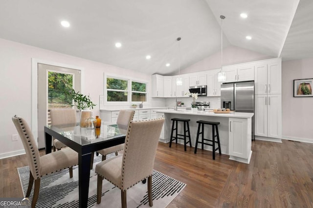 dining room featuring dark hardwood / wood-style flooring and vaulted ceiling