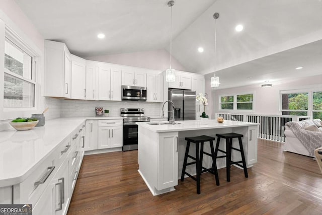 kitchen featuring white cabinetry, a center island with sink, pendant lighting, and appliances with stainless steel finishes