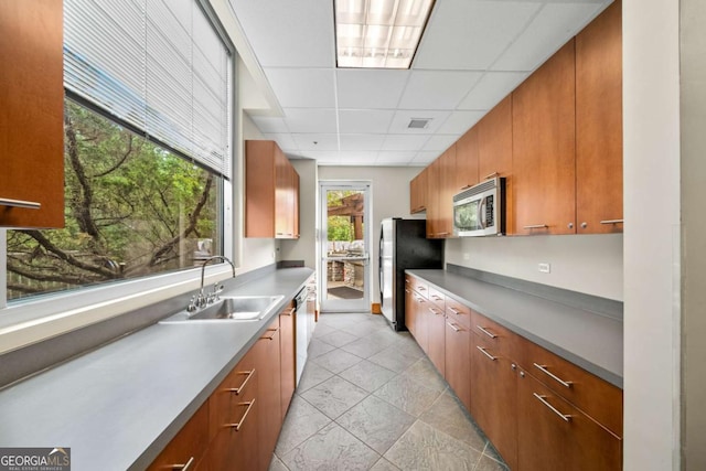 kitchen with appliances with stainless steel finishes, a paneled ceiling, and sink