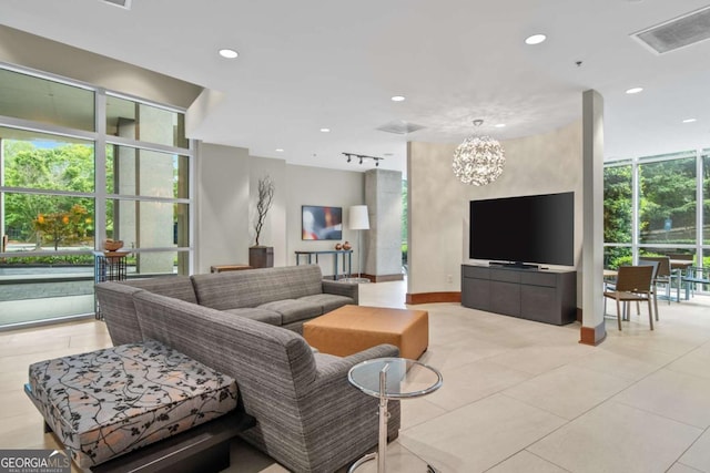 tiled living room featuring an inviting chandelier and a wealth of natural light