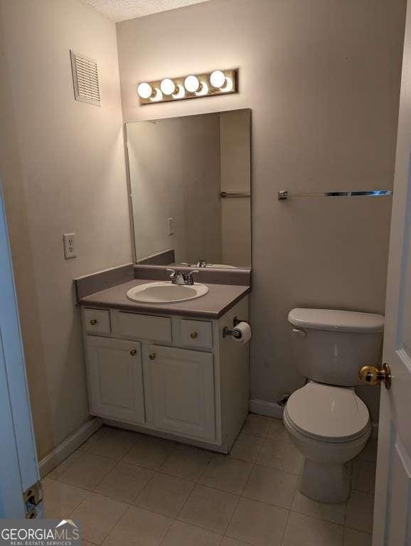 bathroom with tile patterned floors, vanity, and toilet