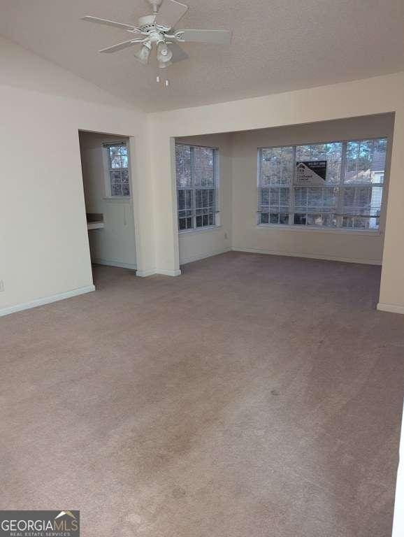 carpeted spare room featuring ceiling fan